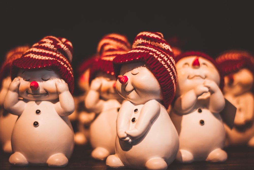 Several baby snowmen with hats, smiling and laughing at jokes