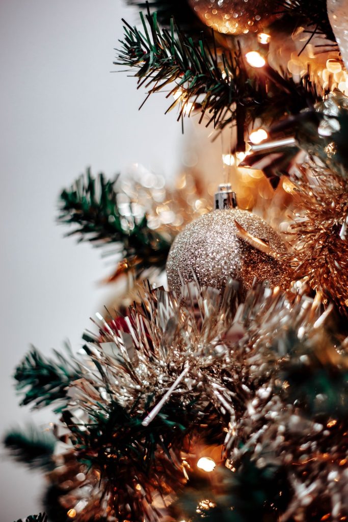 Edge of Christmas tree with lights and silver ball. 