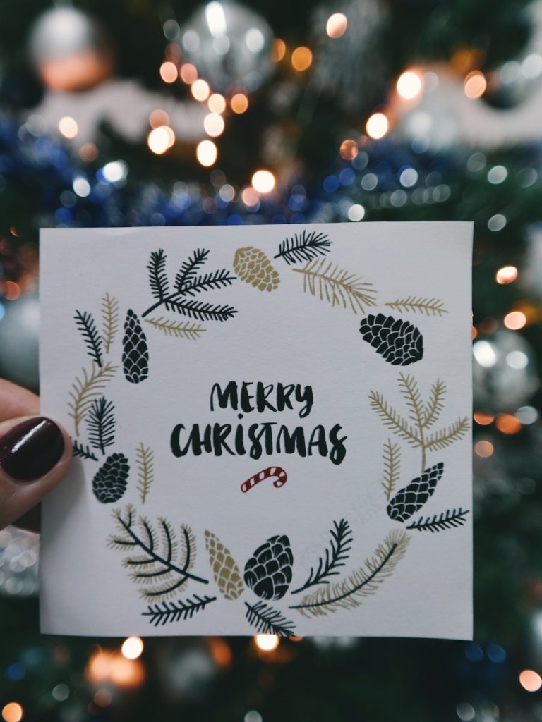 Christmas card with Merry Christmas and drawn wreath with acorns and branches