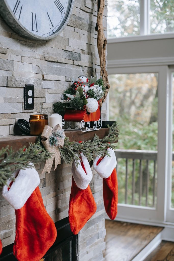 Red and white felt Christmas stockings hanging on mantel of fireplace