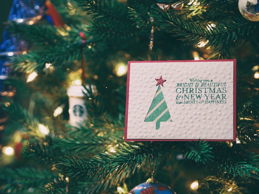 Christmas card propped on Christmas tree