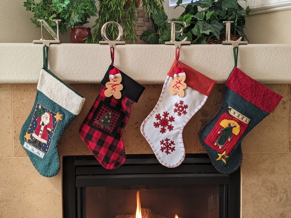 Four handmade Christmas stockings hanging on mantel