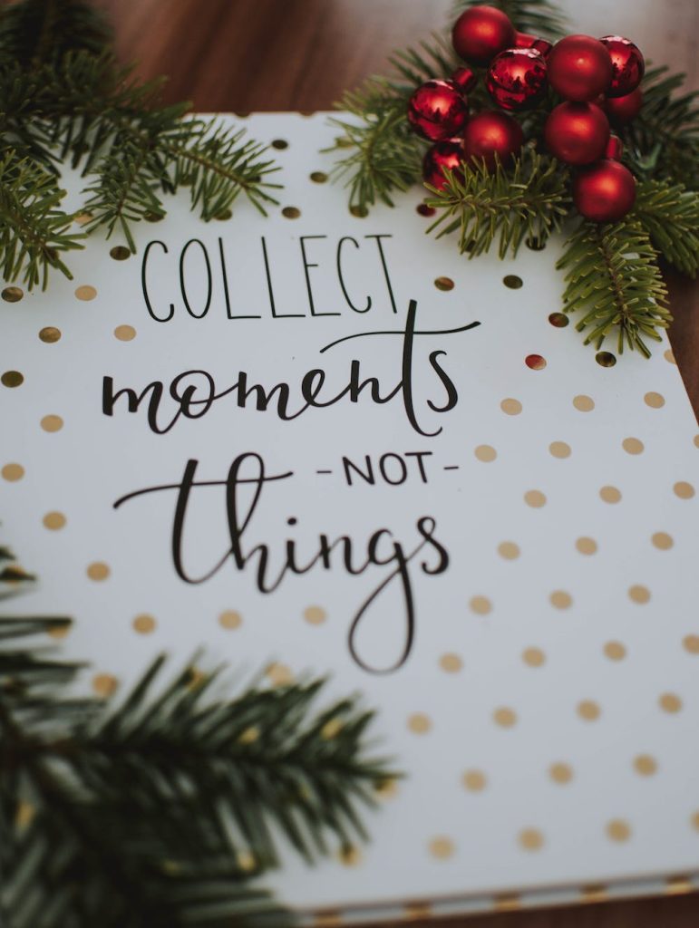 Words Collect moments not things on white paper with gold dots