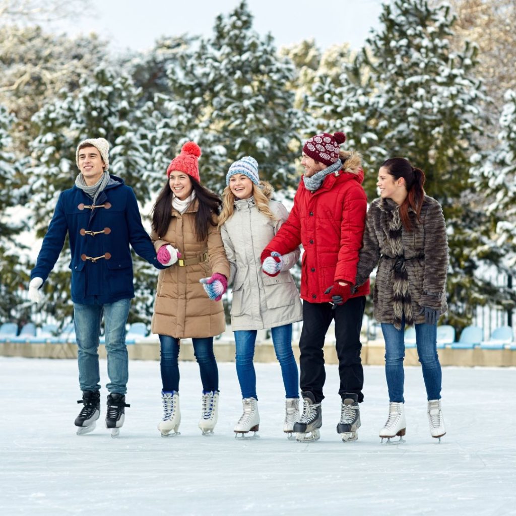 Five people ice skating outside to show how to prepare for holiday guests with outdoor activities.