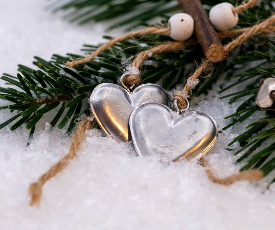 Two heart ornaments on a tree branch demonstrating the act of gifiting collections to loved ones.