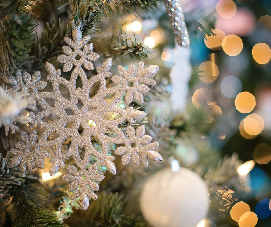 Snowflake ornament hanging on a Christmas tree.