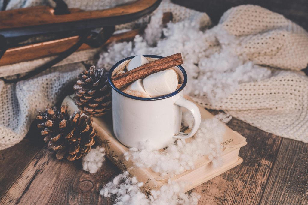Self care during the holidays with hot chocolate, warm sweater and good book.