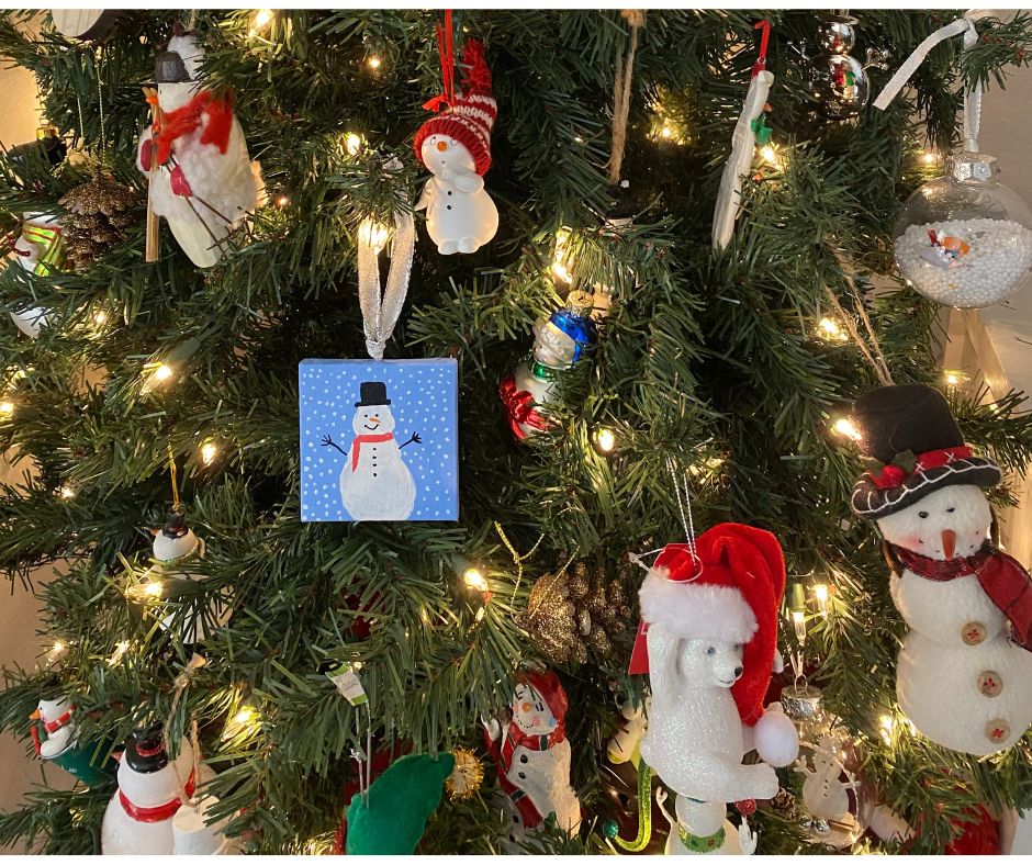 Snowmen ornaments on a tree to show the act of gifting collections with ornaments.