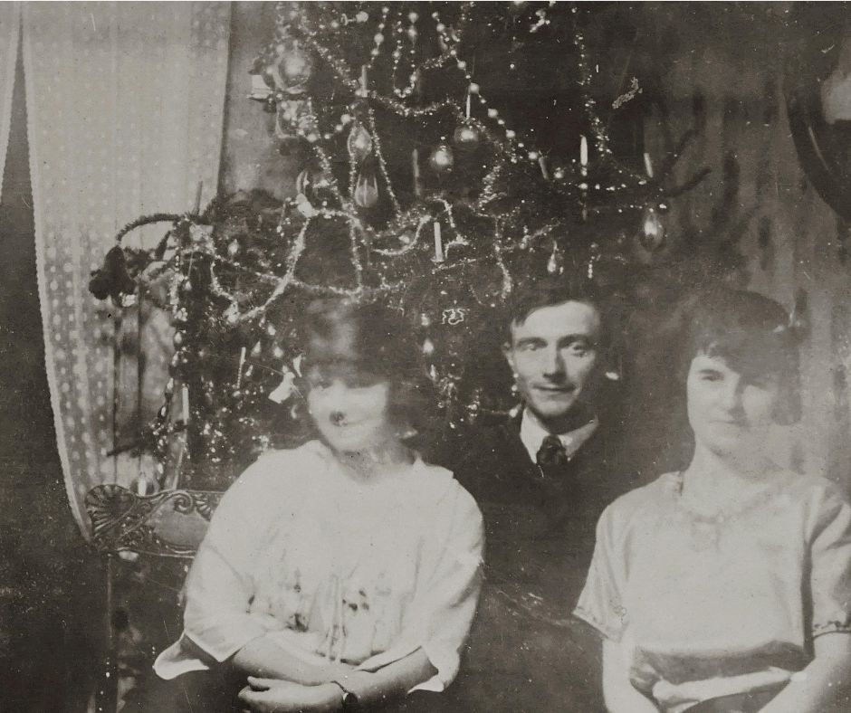 Vintage black and white photo of family in front of Christmas tree.