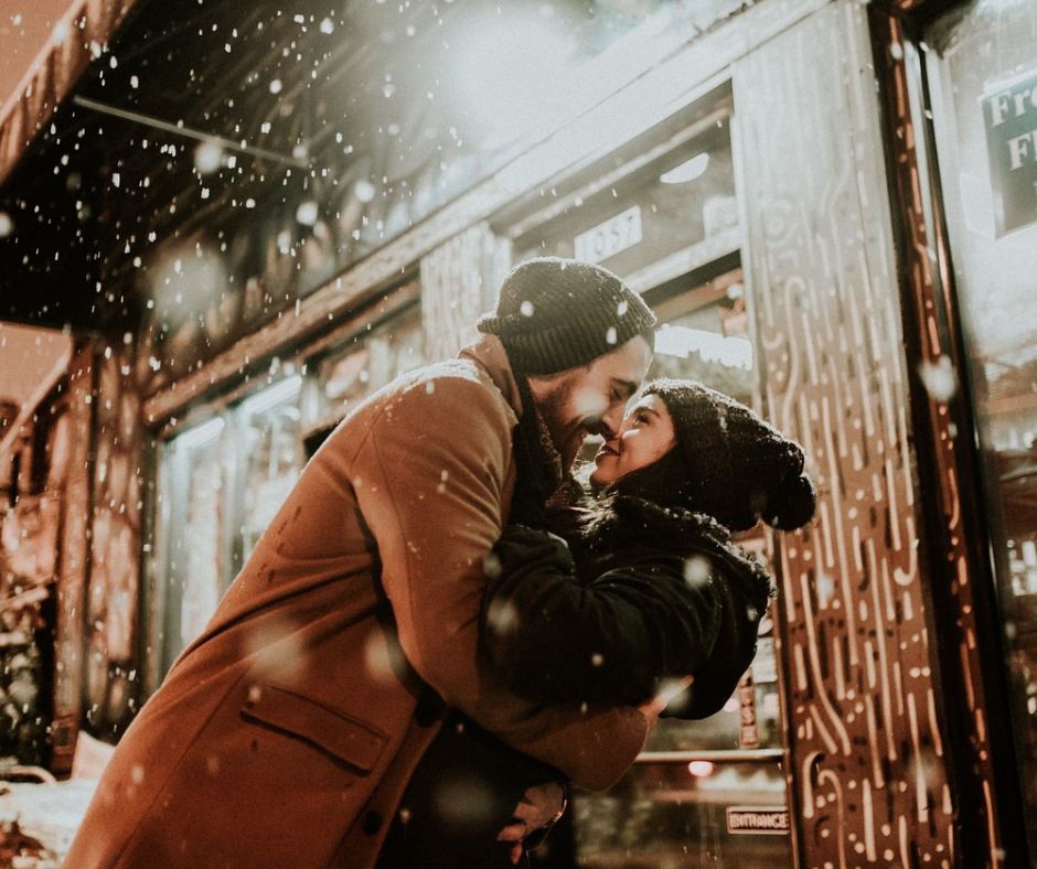 Couple hugging outside in the winter.