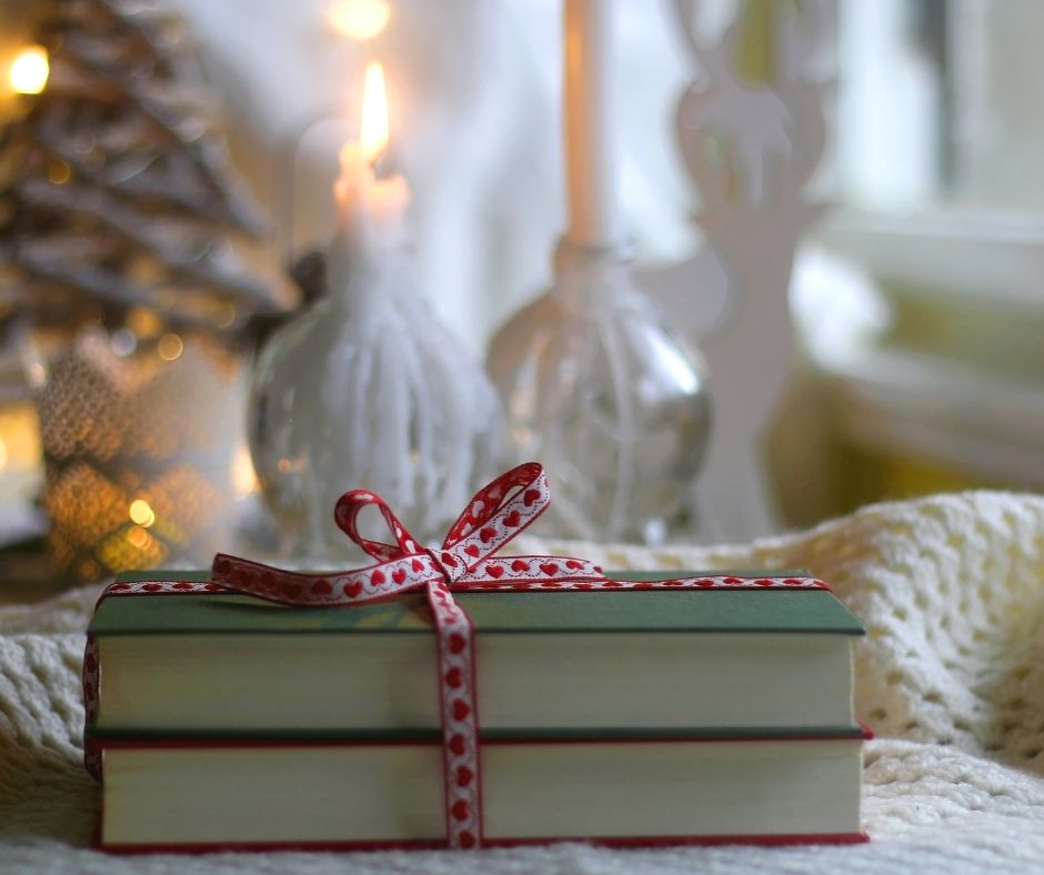 Christmas books on table with red and white ribbon
