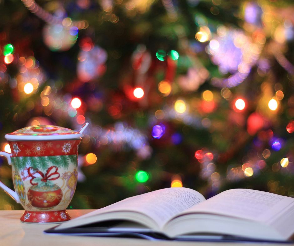 One of the Christmas books with decorative coffee mug in front of Christmas tree