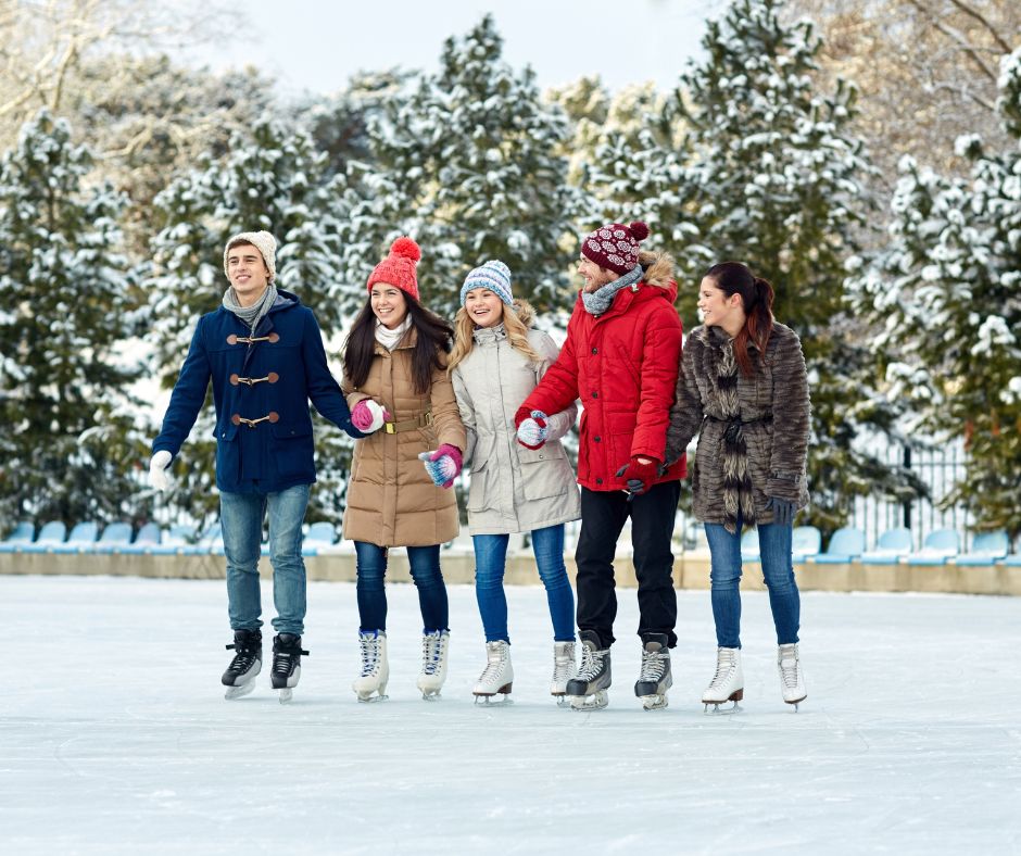 5 people holding hands on outdoor skating ring as one of Christmas party themes.