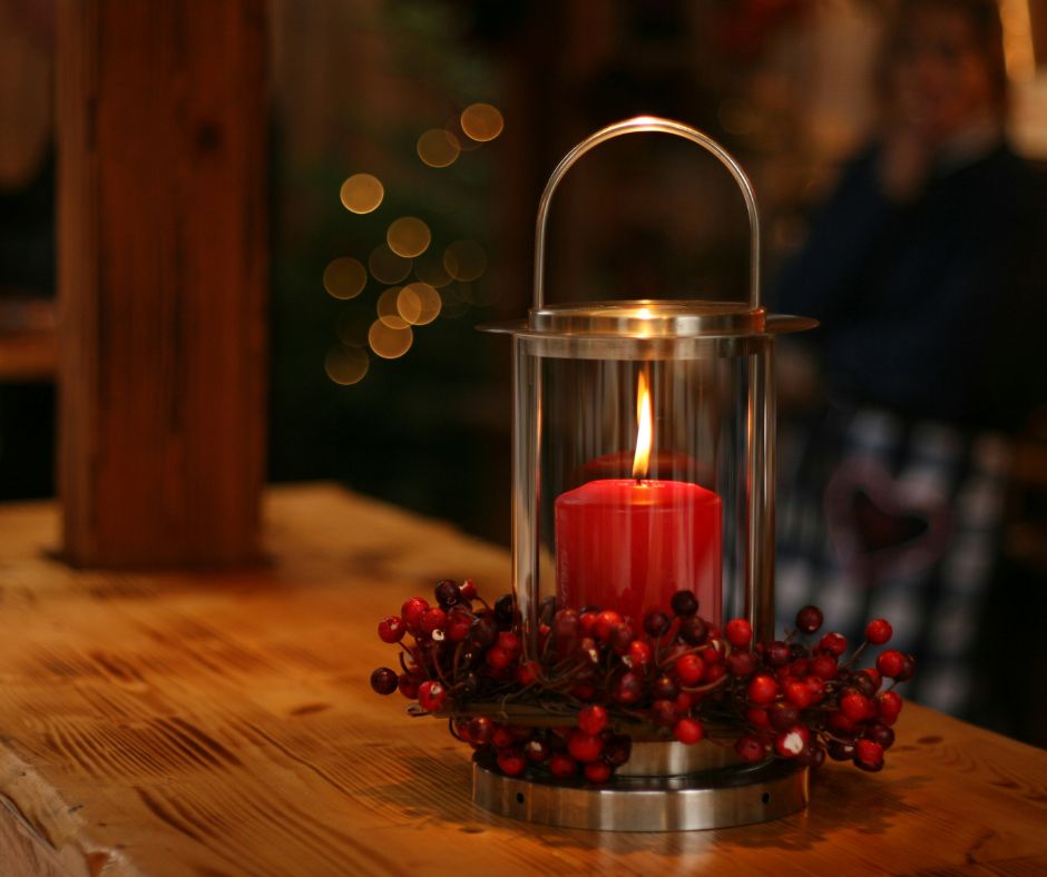 Summer Joy Inspired by Christmas by lighting a candle, shows red candle in brass case.