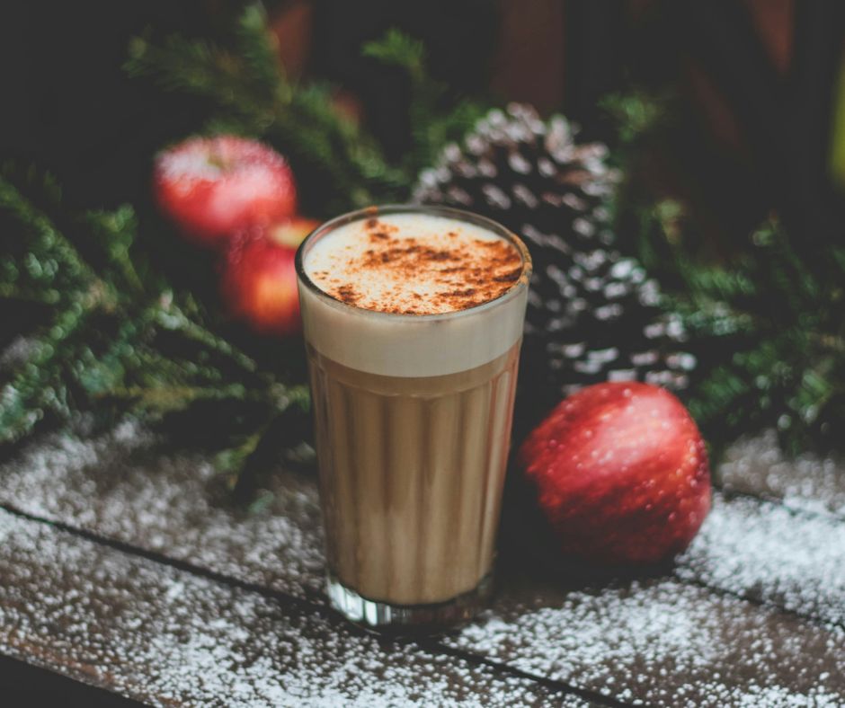 Shows glass of chocolate drink with whipped cream and cinnamon to represent summer joy inspired by Christmas.