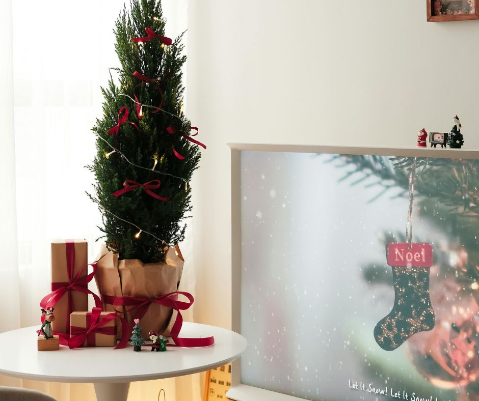 Small tree with red ribbon on a white table as Christmas decor for apartments